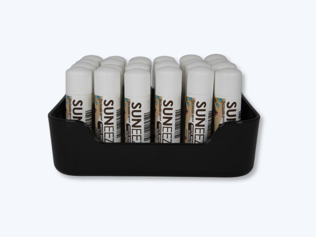 Black countertop display tray holding lip balm tubes